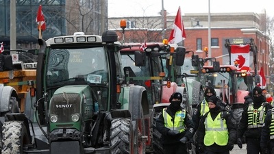 Police officers walk past parked tractors, as truckers and supporters continue to protest coronavirus disease (COVID-19) vaccine mandates, in Ottawa, Ontario, Canada.