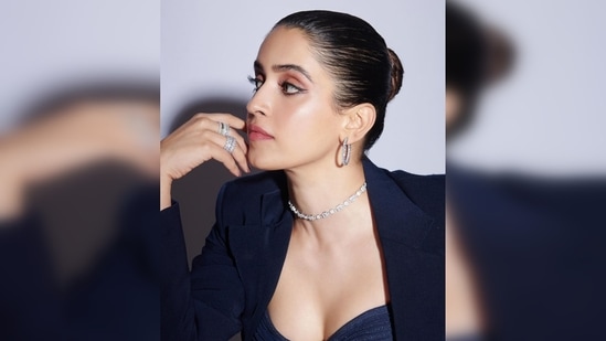 In her latest Instagram pictures, Sanya Malhotra was spotted donning a black sleeveless bodysuit paired with high rise flared pants and a blazer to give her look a complete formal look.(Instagram/@sukritigrover)