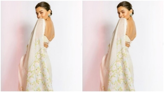 Alia decked up in an ivory white saree embroidered in golden resham threads. She teamed it with a strappy white blouse with white tassels in the back.(Instagram/@aliabhatt)
