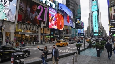 Pedestrians walk through Times Square while taking pictures in New York. Visitors again crowd below the jumbo screens in New York’s Times Square (AP) Pedestrians walk through Times Square while taking pictures in New York. Visitors again crowd below the jumbo screens in New York’s Times Square (AP)