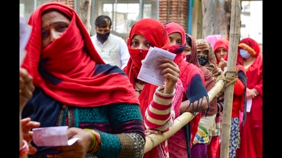 Women stand in a queue to cast their votes, during the first phase of UP polls, at a polling station at Vaidpura village, in Gautam Buddha Nagar on Thursday. (PTI)