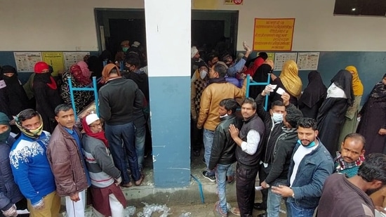 Voters wait in queues to cast their votes at Children Academy School during the first phase of the Uttar Pradesh Assembly elections, in Aligarh.