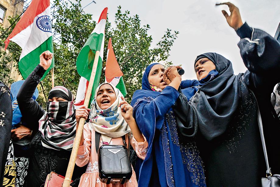 Indian Muslim women shout slogans during a protest against banning Muslim girls wearing hijab from attending classes at some schools in the southern Indian state of Karnataka, in Kolkata, India, Thursday, February. 10, 2022. (AP Photo/Bikas Das)