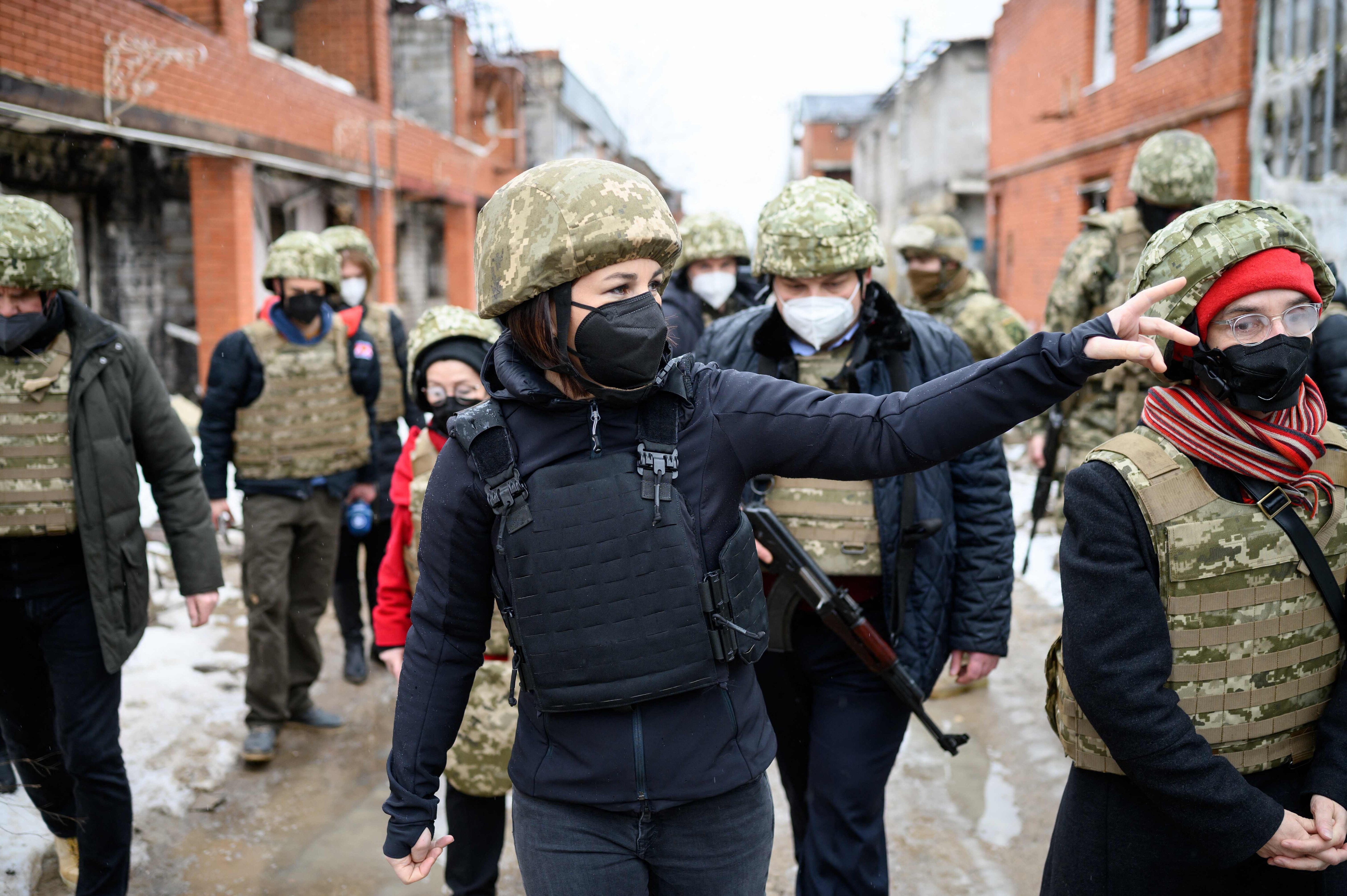 German foreign minister Annalena Baerbock (C) gesticulates during a visit in Shyrokyne, Donetsk Region, Ukraine, on February 8, 2022. (Photo by Bernd von Jutrczenka/POOL/AFP)