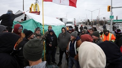In picture - People debate whether or not to open one lane of traffic as truckers and supporters continue blocking access to the Ambassador Bridge, which connects Detroit and Windsor, in protest against Covid-19 vaccine mandates, in Windsor, Ontario, Canada. (Reuters)