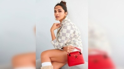 Deepika Padukone paired her look with beige boots, white knee-high socks and a red Louis Vuitton handbag. ( Instagram/@shaleenanathani) Deepika Padukone paired her look with beige boots, white knee-high socks and a red Louis Vuitton handbag. ( Instagram/@shaleenanathani)