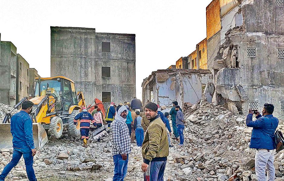 Rescue work in progress after a portion of a building collapsed in a JJ Colony at Bawana, in New Delhi, Friday, Feb 11, 2022. Several people are feared to be trapped in the debris. (PTI Photo) Rescue work in progress after a portion of a building collapsed in a JJ Colony at Bawana, in New Delhi, Friday, Feb 11, 2022. Several people are feared to be trapped in the debris. (PTI Photo)