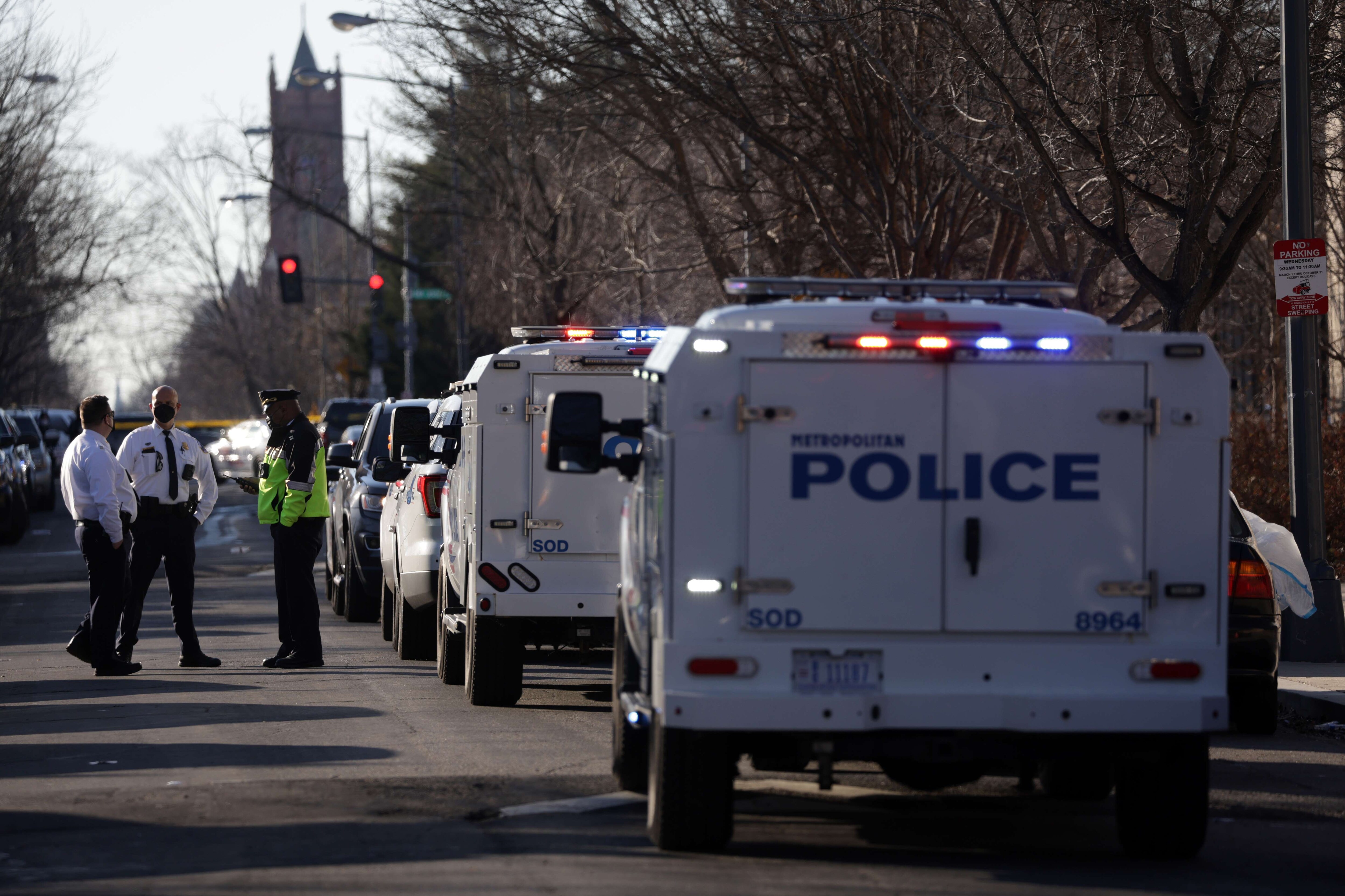 Police officers wait outside Dunbar High School as members of the Metropolitan Police Department of the District of Columbia conduct an investigation of a security threat at the school on February 8, 2022 in Washington, DC. Doug Emhoff, husband of Vice President Kamala Harris, was removed from the school building by Secret Service agents due to the threat while he was attending an event in commemoration of Black History Month. (Alex Wong/Getty Images/AFP)