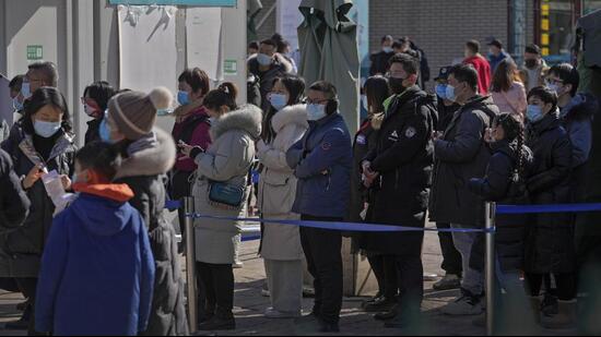 Residents wearing masks line up to get a throat swab for Covid-19 test at a hospital in Beijing. China has given conditional approval for Pfizer’s oral drug Paxlovid to treat adults with mild to moderate infection but with a high risk of developing severe disease. (AP)