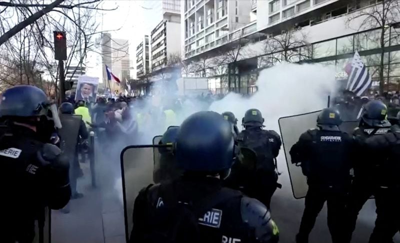 French police use teargas while facing demonstrators in this screen grab taken from a video during a "Convoi de la liberte" (The Freedom Convoy), a vehicular convoy to protest coronavirus disease (Covid-19) vaccine and restrictions in Paris, France, on February 12, 2022. (REUTERS via Reuters TV)