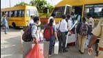 Polling officials with election material board a bus to reach their respective polling stations, a day before the Goa Assembly elections, at Dr Shyama Prasad Mukherjee Stadium at Taleigao in Goa on Sunday. (PTI PHOTO.)