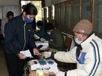 In picture - Polling official administering indelible ink to a voter.