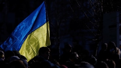 A person holding the Ukrainian flag during a protest in Kyiv, Ukraine. (REUTERS)