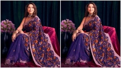 Madhuri paired the gorgeous saree with a midriff-baring sleeveless blouse intricately embroidered in silver and violet details. She accessorised her look with a silver and blue choker, ear studs, ring and bangles from the house of My Motifs. (Instagram/@madhuridixitnene)