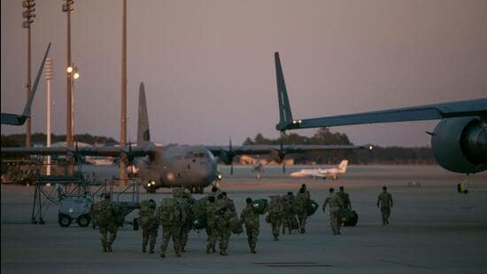 US soldiers line up to board a plane to Europe as the crisis between Russia and Ukraine escalates. (AFP)