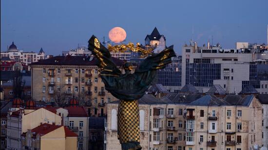 Moon sets over the Independence Monument and buildings in Kiev, Ukraine against the backdrop of heightened tensions over a buildup of Russian troops on the border. (REUTERS)