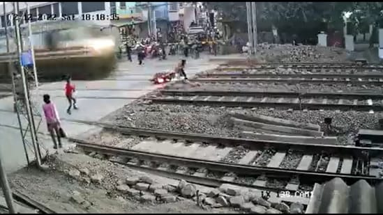Biker escapes a major train accident while trying to cross the railway tracks. (Video screengrab/Twitter)