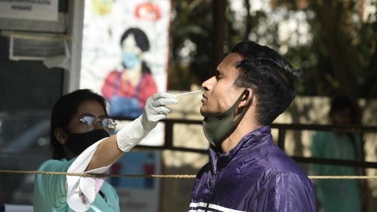 A health worker collects swab samples of a man for Covid-19 testing, in Gurugram. (Parveen Kumar/HT PHOTO)