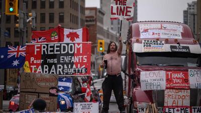 A demonstrator holds a placard during a protest by truck drivers over pandemic health rules and the Trudeau government, outside the parliament of Canada in Ottawa on Wednesday. (AFP) A demonstrator holds a placard during a protest by truck drivers over pandemic health rules and the Trudeau government, outside the parliament of Canada in Ottawa on Wednesday. (AFP)