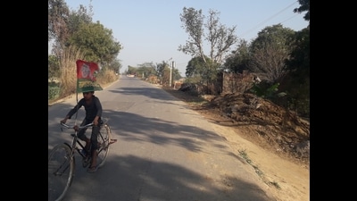 A child riding on Saifai-Jaswant Nagar road with the SP flag fastened to his bicycle. (Pankaj Jaiswal/HT Photo)