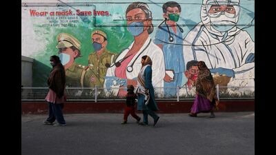 Women walk past a graffiti in New Delhi, February 7, 2022 (REUTERS) Women walk past a graffiti in New Delhi, February 7, 2022 (REUTERS)