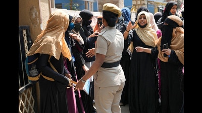 Muslim students, wearing burqa or hijab, interact with a policewoman as they gather to protest against the principal of their government-run school, Bengaluru, February 17, 2022 (AP) Muslim students, wearing burqa or hijab, interact with a policewoman as they gather to protest against the principal of their government-run school, Bengaluru, February 17, 2022 (AP)