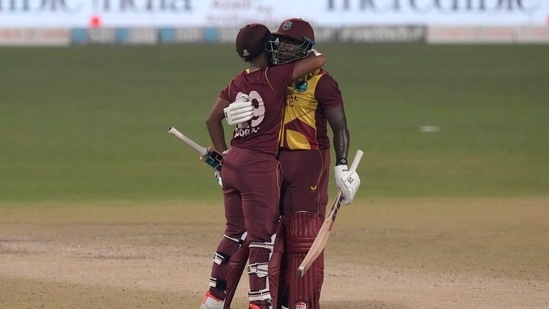 West Indies' Nicholas Pooran, left, hugs his batting partner Rovman Powell to celebrate scoring fifty runs during the second Twenty20 international cricket match between India and West Indies in Kolkata, India, Friday, Feb. 18, 2022.(AP)