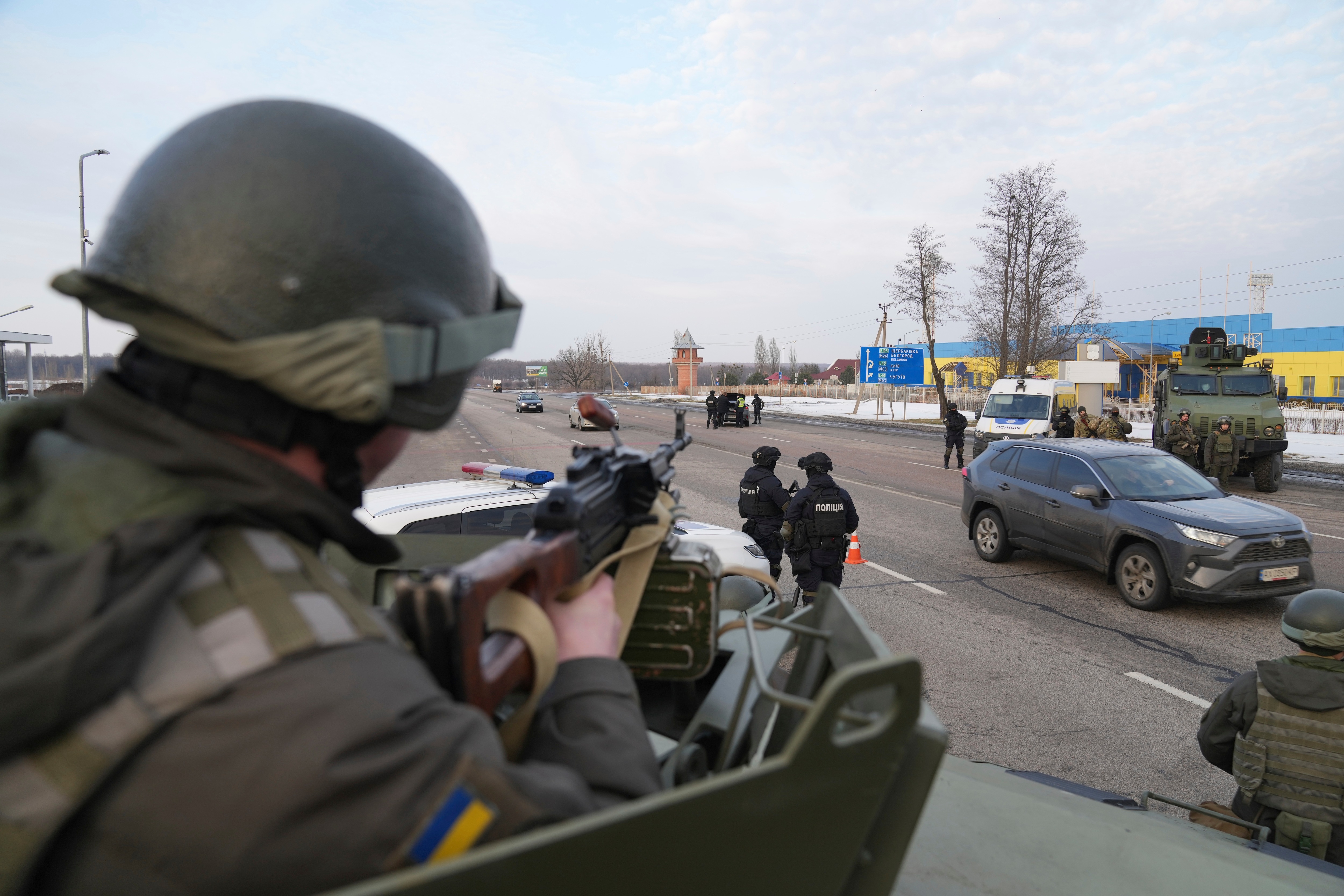 A Ukrainian National guard soldier, left, holds his weapon ready as he guards the mobile checkpoint with the Ukrainian Security Service agents and police officers in Kharkiv on, Feb. 17, 2022.&nbsp; (AP)