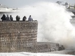 People take pictures as waves break on during Storm Eunice, in Brighton, Britain, February 18, 2022. REUTERS/Peter Nicholls