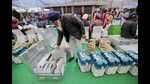 A polling official takes out an Electronic Voting Machine (EVM) from the case at a distribution centre on the eve of Punjab Assembly elections, in Amritsar on Saturday. (Raminder Pal Singh)