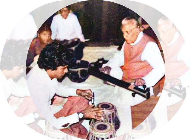 Fine tuning instruments with his guruji while preparing for a concert Fine tuning instruments with his guruji while preparing for a concert