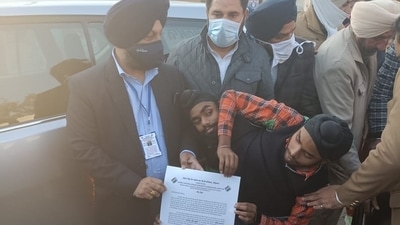 Deputy commissioner Gurpreet Singh Khaira handing over certificate to first-time voters Sohna and Mohna who are conjoined twins but cast separate votes on Sunday.&nbsp; (Sameer Sehgal/ Hindustan Times)
