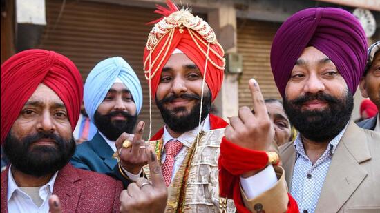 A groom shows his inked finger after casting his ballot at a polling station in a village on the outskirts of Amritsar on Sunday during the Punjab elections. The polling finished peacefully in the Majha region with no major incidents of violence being reported from anywhere. (AFP)