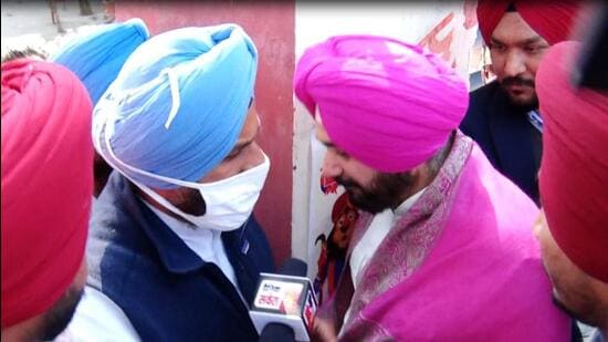 Punjab Congress president Navjot Singh Sidhu and SAD leader Bikram Singh Majithia are competing with each other for the Amritsar East assembly seat. As Sidhu was entering the poll booth building in the Verka area of the city, he came across Majithia, who was emerging out of the booth. (HT Photo)