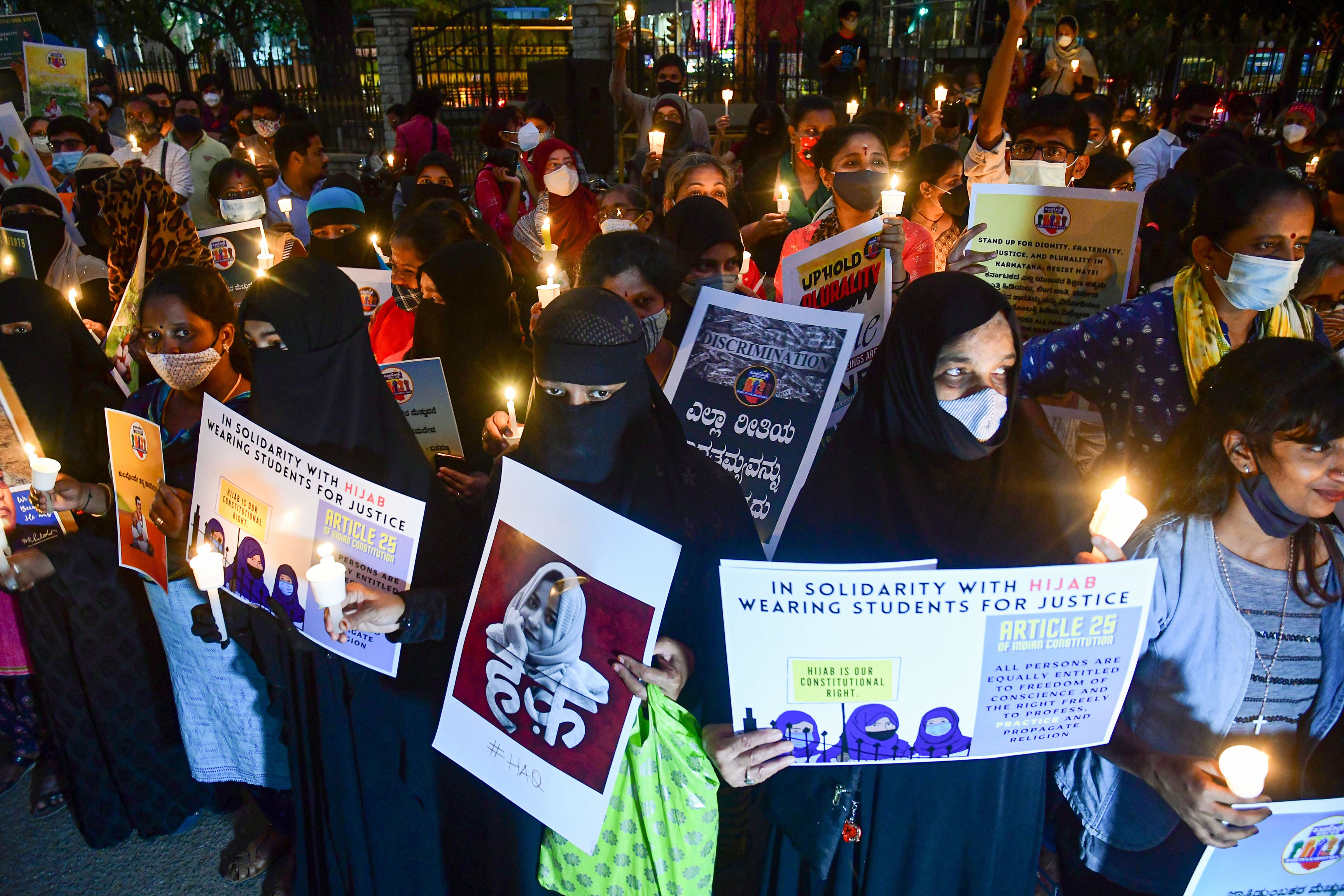 Citizens hold placards and candles in support of the hijab-wearing students, Bengaluru, February 19, 2022. (PTI) Citizens hold placards and candles in support of the hijab-wearing students, Bengaluru, February 19, 2022. (PTI)