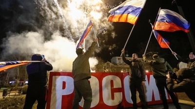 Pro-Russian activists react in a street as fireworks explode in the sky, after Russian President Vladimir Putin signed a decree recognising two Russian-backed breakaway regions in eastern Ukraine as independent entities, in the separatist-controlled city of Donetsk. (REUTERS)