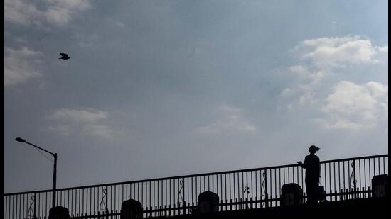 A man stands on Sambhaji bridge (Lakdi Pul) on a partly cloudy evening in Pune, on Saturday. With the current La Nina conditions prevailing, the southwest monsoon this year is likely to be normal as per weather scientists. (Pratham Gokhale/HT Photo)