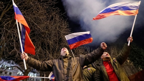 Pro-Russian activists react on a street as fireworks explode in the sky, after Russian President Vladimir Putin signed a decree recognising two Russian-backed breakaway regions in eastern Ukraine as independent entities, in the separatist-controlled city of Donetsk, Ukraine.(REUTERS)