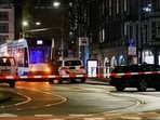 A police officer stands next to a police vehicle near an Apple store in central Amsterdam during a hostage incident in the store, in Amsterdam, Netherlands.