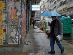 A man wearing a face mask, walks on a street in Hong Kong. A man wearing a face mask, walks on a street in Hong Kong.