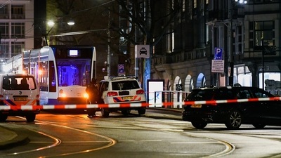 A police officer stands next to a police vehicle near an Apple store in central Amsterdam during a hostage incident in the store, in Amsterdam, Netherlands. (REUTERS)