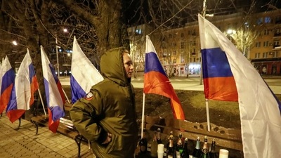 A pro-Russian activist stands next to flags in a street, after Russian President Vladimir Putin signed a decree recognising two Russian-backed breakaway regions in eastern Ukraine as independent entities, in the separatist-controlled city of Donetsk, Ukraine February 21, 2022. REUTERS/Alexander Ermochenko (REUTERS)