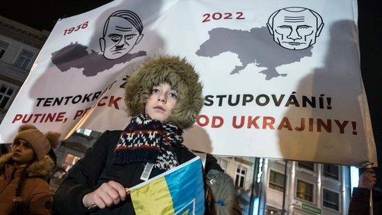 A young protester holding a Ukrainian flag takes part in a demonstration in support to Ukraine.(AFP)