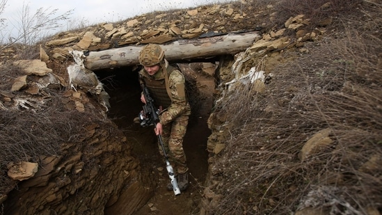 A Ukrainian serviceman walks along a trench at a position on the front line with Russia-backed separatists near the settlement of Troitske in the Lugansk region.(AFP)