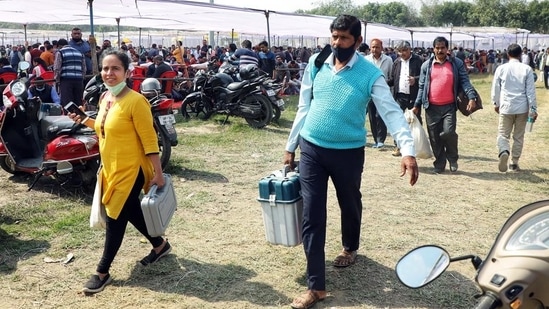 Polling officials carrying Electronic Voting Machines and other polling equipment after collecting it from the distribution center, for the fourth phase of the Uttar Pradesh Assembly Election, in Lucknow.(ANI)