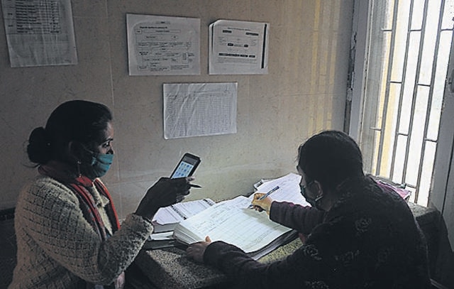 Health staff relying on a mobile phone’s torchlight to enter patient details at the Sector-19 Government Dispensary in Chandigarh. (Ravi Kumar/HT)