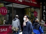 Pedestrians wearing face masks following the coronavirus disease (Covid-19) outbreak, walk past a closed jewellery store at the Central district in Hong Kong, China&nbsp;