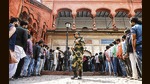 Paramilitary personnel stand guard while voters wait in queues to cast their votes for phase 4 of UP elections, in Lucknow on Wednesday. (ANI)