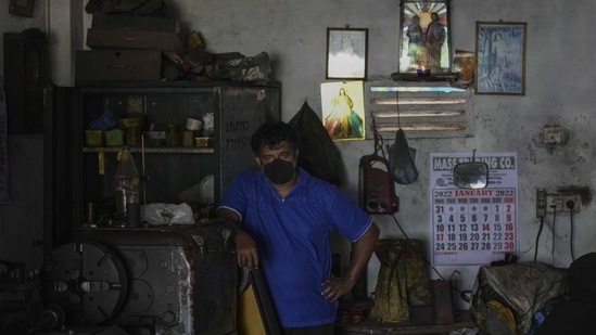 A Sri Lankan workshop owner pauses his work and waits during a power cut in Wattala, a suburb of Colombo (AP)