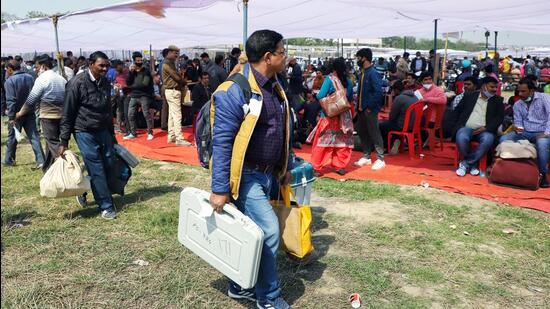 Polling officials carrying Electronic Voting Machines. (ANI)